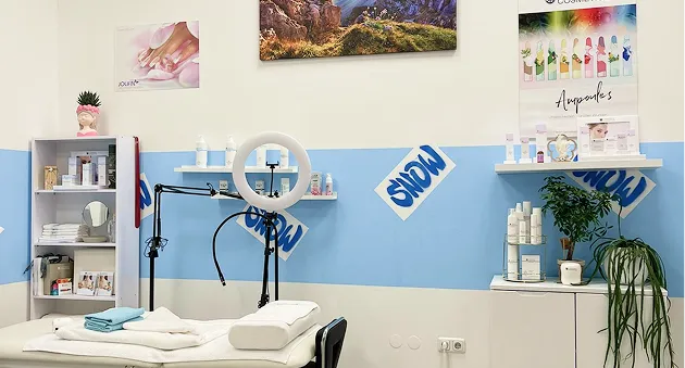 Ein Bild von der Liege mit Regalen mit Kosmetikprodukten im Hintergrund, alles Dekorativ eingerichtet